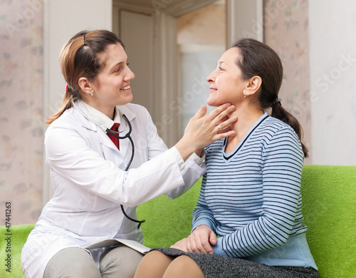 Photo: Doctor touching neck of patient Doctor touching neck of patient