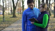 Male jogger with personal trainer in park, crane shot