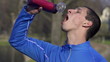 Man drinking water, woman jogging, super slow motion
