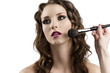 Photo: girl getting made-up by hands with brushes, looks at right girl getting made-up by hands with brushes, looks at right