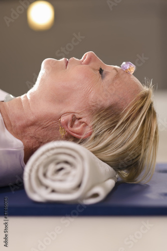 Photo: Senior woman relaxing and doing therapy with crystals Senior woman relaxing and doing therapy with crystals