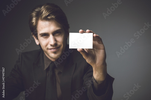Photo: Young man presenting a businesss card Young man presenting a businesss card