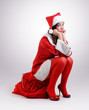 Foto: Santa girl with a red bag of gifts Santa girl with a red bag of gifts