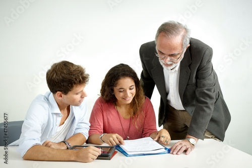 Photo: Teacher giving instructions to a couple of students Teacher giving instructions to a couple of students