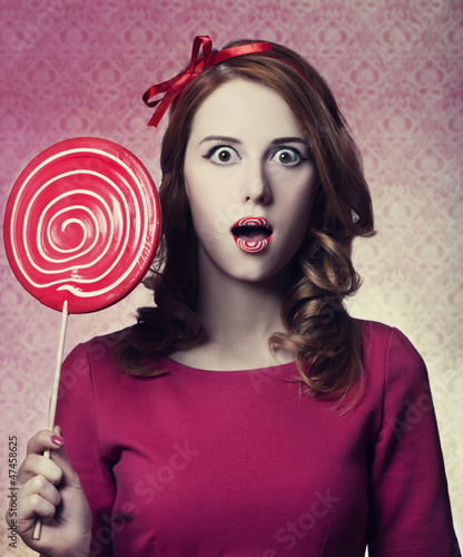 Photo: Beautiful redhead girl with lollipop. Photo in retro style. Beautiful redhead girl with lollipop. Photo in retro style.