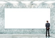 Business person standing near a blank billboard