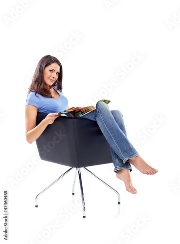 Photo: Casual 20s women sitting with magazine, looking to camera Casual 20s women sitting with magazine, looking to camera