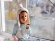 Photo: winter boy sitting by the window in a white knitted cap winter boy sitting by the window in a white knitted cap
