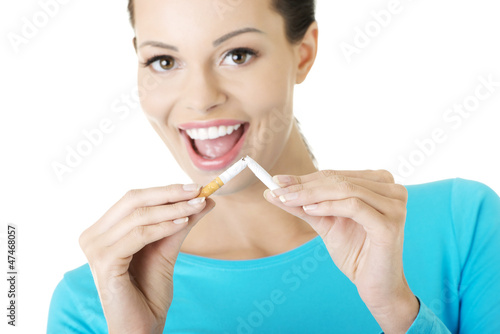 Photo: Young woman with broken cigarette. Stop smoking concept. Young woman with broken cigarette. Stop smoking concept.
