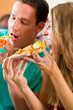 Mann und Frau essen eine Pizza