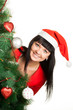 Photo: Woman in red cap looking out of Christmas tree Woman in red cap looking out of Christmas tree