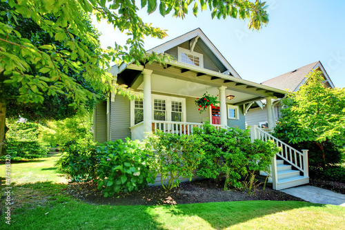 Photo: Grey small house with porch and white railings. Grey small house with porch and white railings.