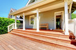 Back porch of small grey house with bench