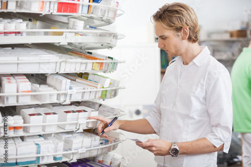 Photo: Male Pharmacist Filling Prescription Male Pharmacist Filling Prescription