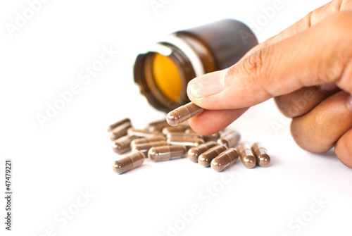 Photo: Hand putting medicine isolated on the white. Hand putting medicine isolated on the white.
