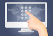 Hand touching button on monitor screen.