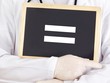 Doctor shows information on blackboard: equals sign
