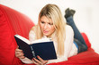 Blondine mit Buch auf der Couch