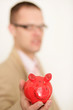 Mann mit rotem Sparschwein