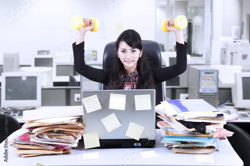 Photo: Businesswoman exercise in office Businesswoman exercise in office