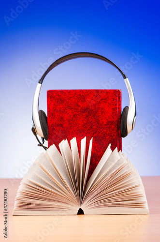 Photo: Concept of audio books with earphones on white Concept of audio books with earphones on white