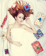 Redhead girl in bed with gifts. Photo in warm tone style.