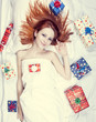 Redhead girl in bed with gifts. Photo in warm tone style.