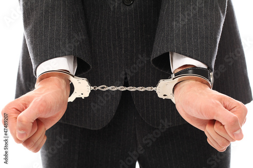 Photo: Close up of businessman hands in handcuffs Close up of businessman hands in handcuffs