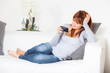 Photo: Beautiful Young Woman with Smartphone on the Sofa Beautiful Young Woman with Smartphone on the Sofa