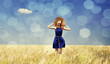 Photo: Redhead girl at spring wheat field. Redhead girl at spring wheat field.