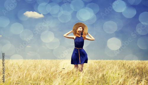 Photo: Redhead girl at spring wheat field. Redhead girl at spring wheat field.