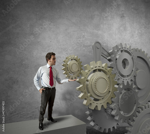 Photo: Businessman turning a gear system Businessman turning a gear system