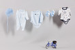 Baby boy clothes, hat and slippers on a clothesline.