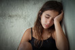 Portrait of a tired and lonely hispanic girl sitting in a corner