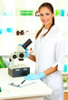 Young scientist looking into  microscope in  laboratory.