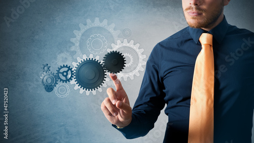 Photo: Businessman and virtual interface with cogwheels Businessman and virtual interface with cogwheels