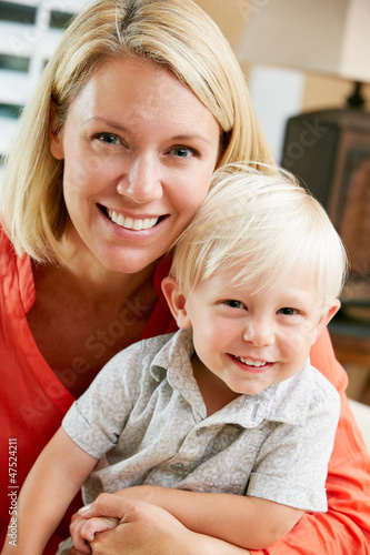 Photo: Portrait Of Mother And Son Sitting On Sofa At Home Portrait Of Mother And Son Sitting On Sofa At Home