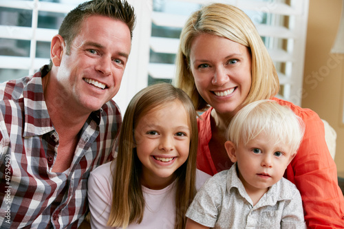 Photo: Portrait Of Family Sitting On Sofa At Home Portrait Of Family Sitting On Sofa At Home