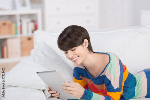 Photo: entspannte frau mit tablet zuhause auf dem sofa entspannte frau mit tablet zuhause auf dem sofa