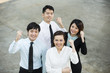 Chinese business team looking up &amp; cheering.