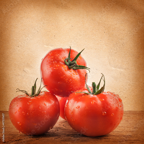 Photo: Tomatoes on the grunge yellow paper background Tomatoes on the grunge yellow paper background