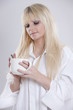 junge blonde Frau mit Tasse Kaffee in der Hand