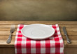 Empty plate on wooden table over grunge background