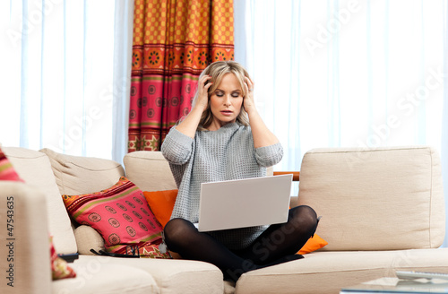 Photo: attractive woman with laptop and headache attractive woman with laptop and headache