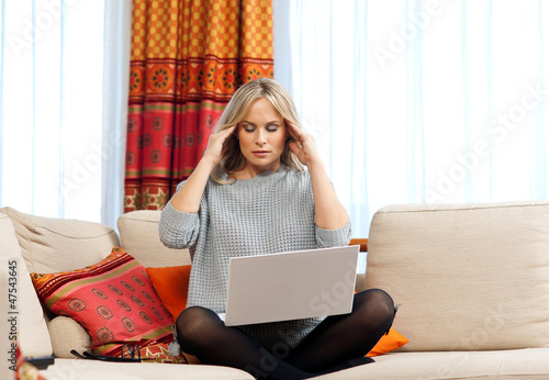 Photo: attractive woman with laptop having migraine attractive woman with laptop having migraine