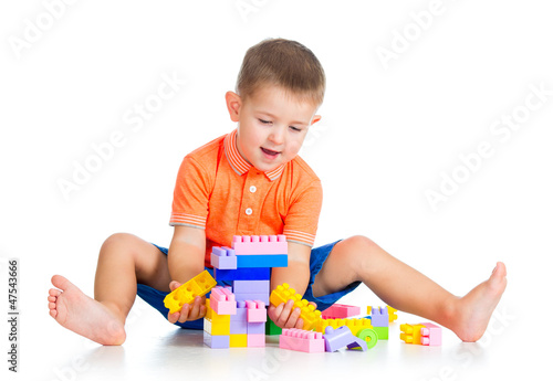 Photo: cheerful child boy playing with construction set over white back cheerful child boy playing with construction set over white back