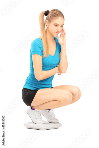 Photo: A young female on a weigth scale A young female on a weigth scale