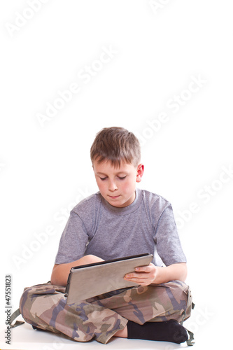 Photo: Teen plays on the tablet computer Teen plays on the tablet computer