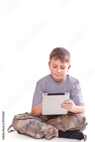 Photo: Teen plays on the tablet computer Teen plays on the tablet computer