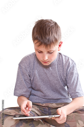 Photo: Teen plays on the tablet computer Teen plays on the tablet computer